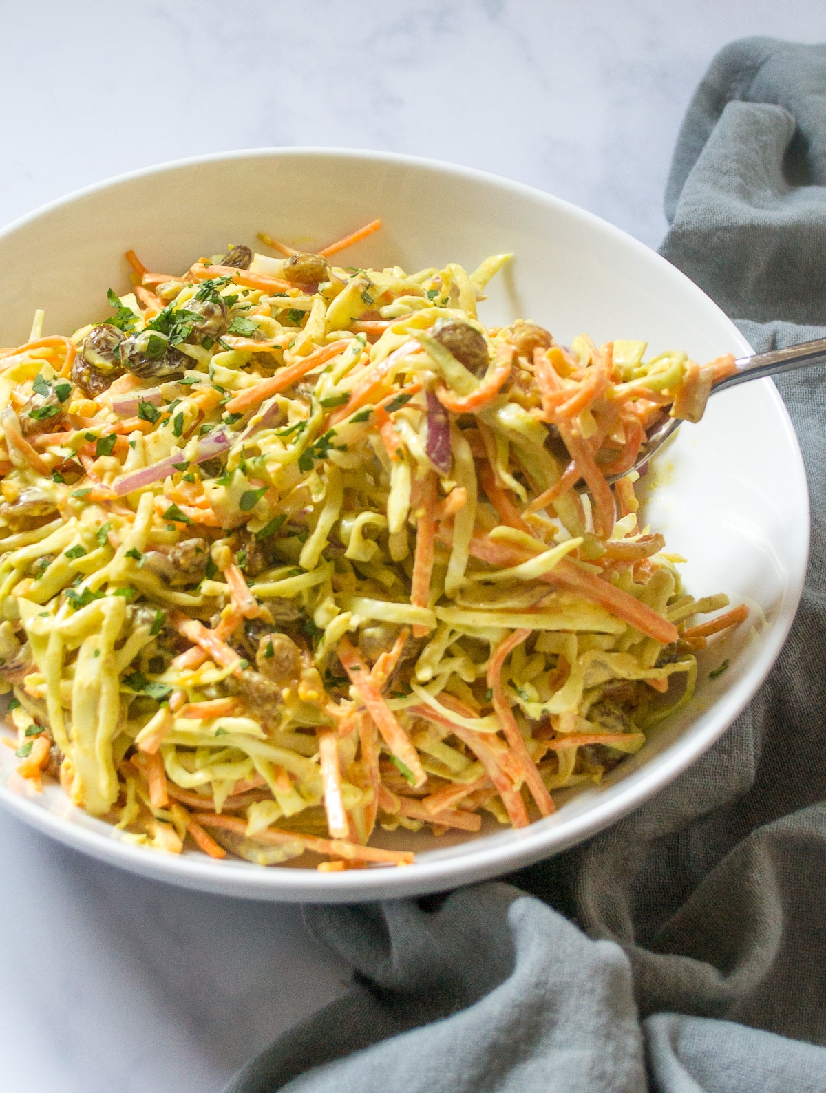 Vegan Coleslaw with spiced mayo spooned out of bowl